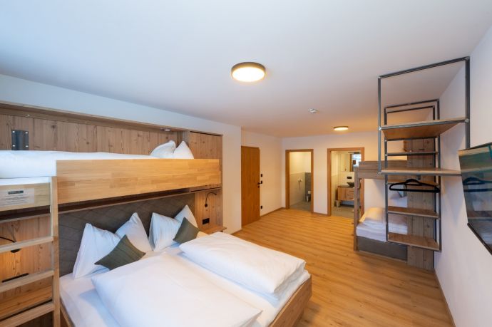 Slaapkamer met tweepersoonsbed en stapelbed